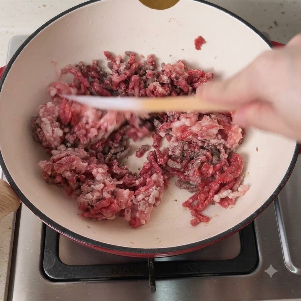 Mixed pork and beef mince being browned in a hot cooking pot.
