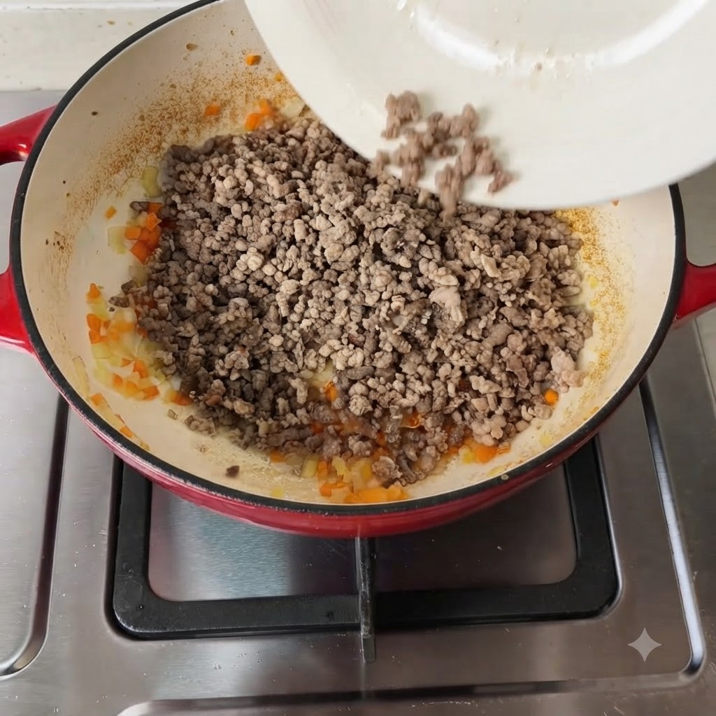 Various seasonings and chopped tomatoes being added to the meat and vegetable mixture.