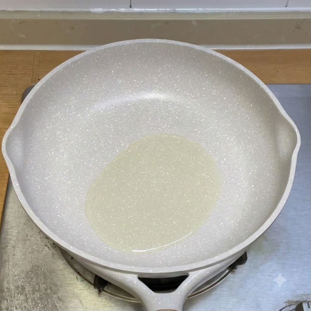 Minced beef being stir-fried in a white frying pan with oil.