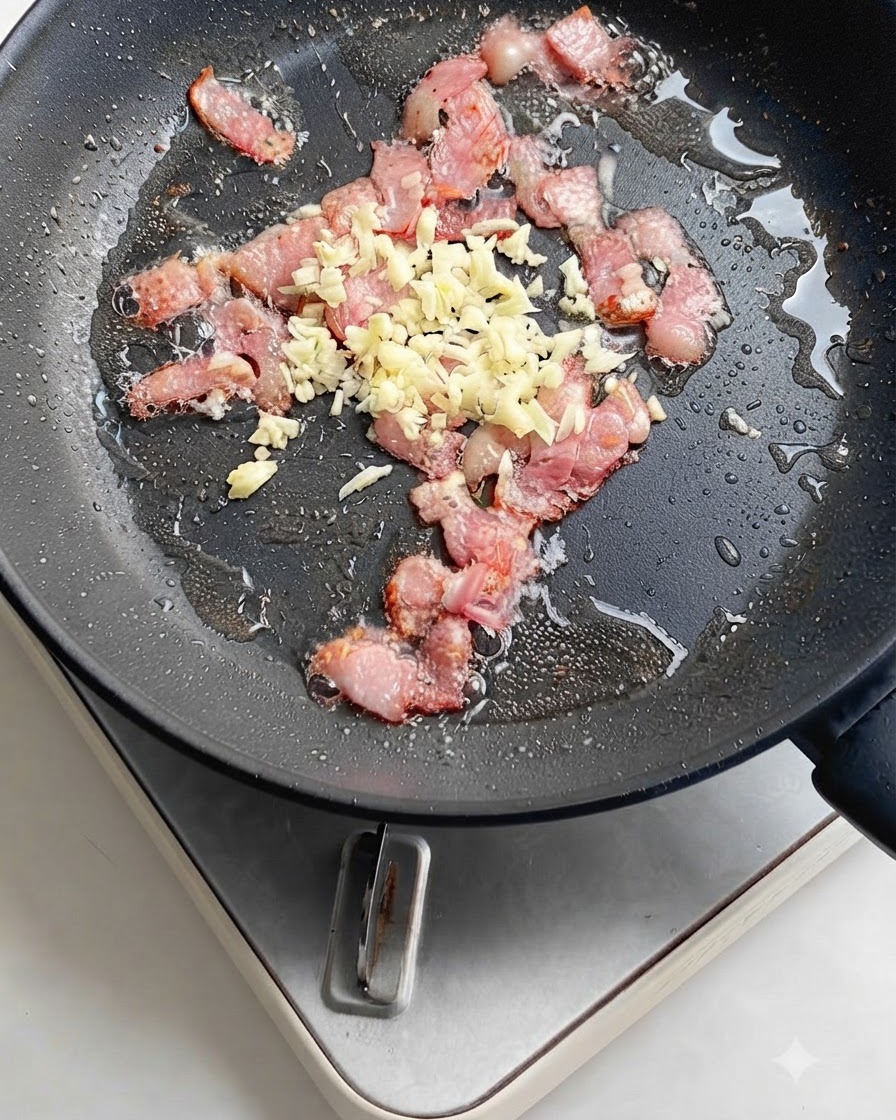 Bright red chili pepper slices added to the pan with sizzling bacon and garlic.