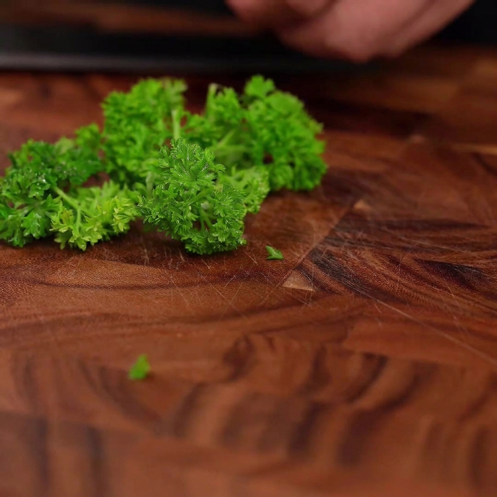 Fresh green parsley leaves arranged on a wooden cutting board, ready to be chopped.