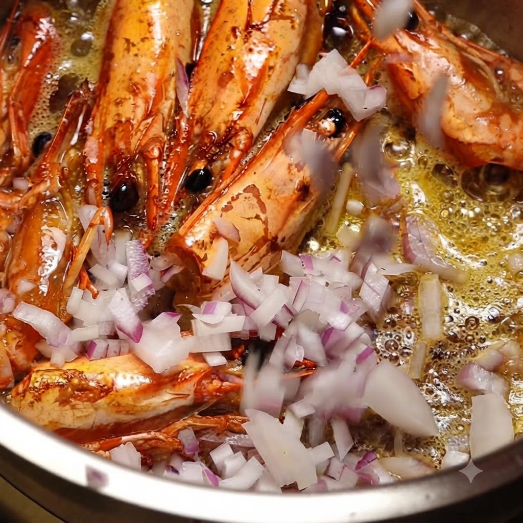 Finely chopped red onions being tossed into a pot containing frying shrimp heads and hot oil.