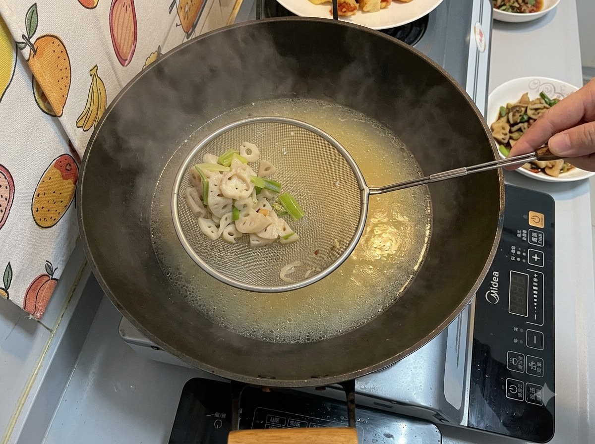 A metal skimmer holding strained solid pieces over a wok filled with a simmering yellowish broth.