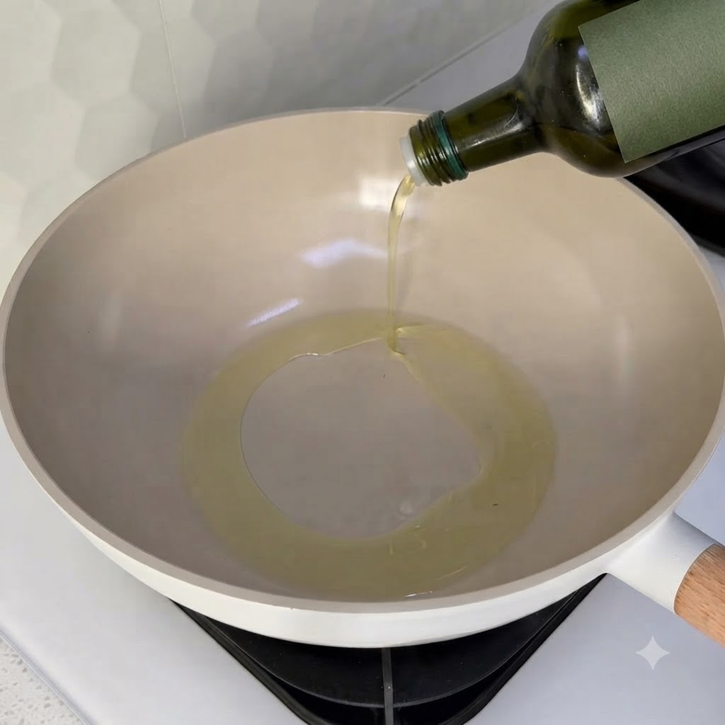 Cooking oil being poured into a clean wok on a stovetop burner.