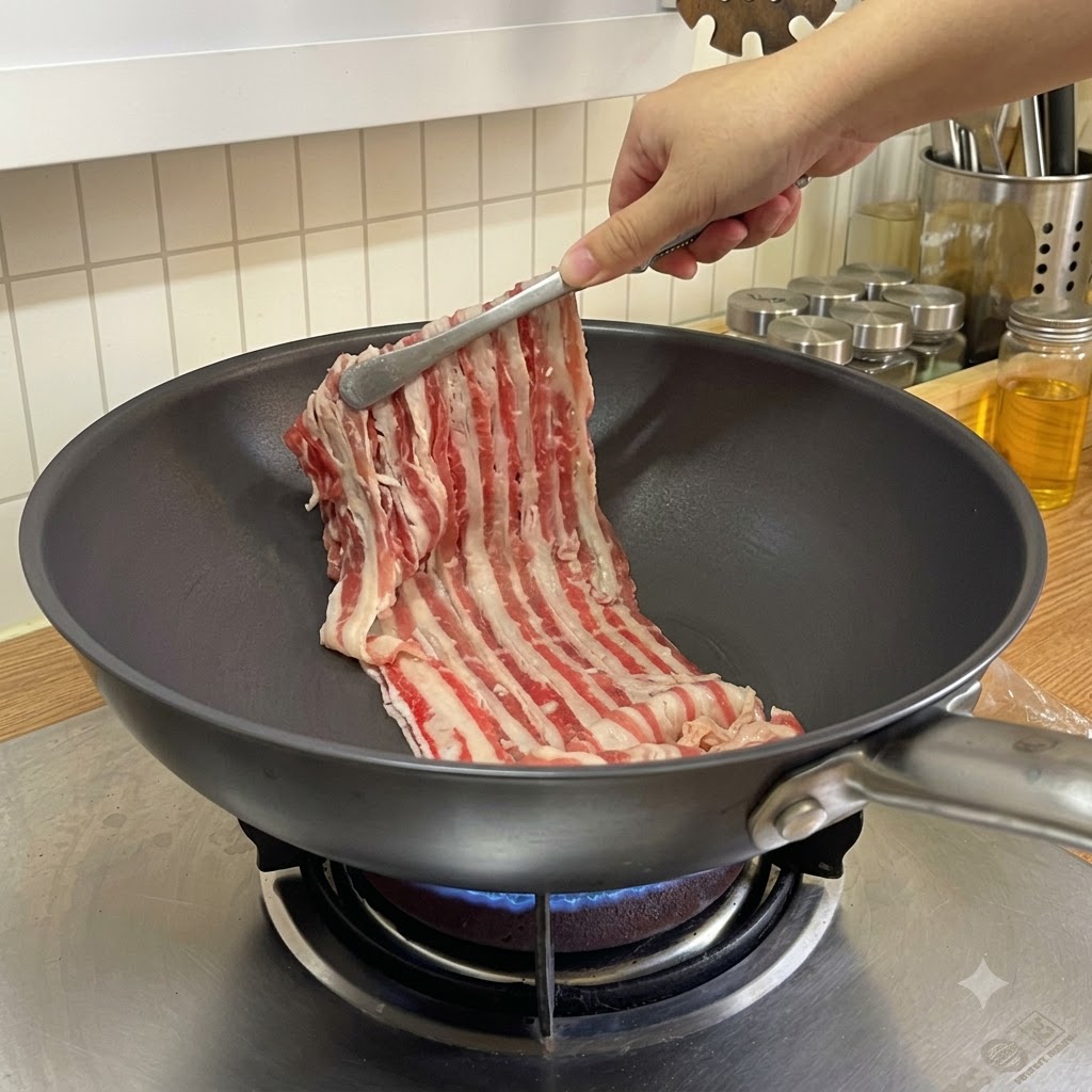 Thinly sliced beef strips being placed into a heated frying pan with tongs.