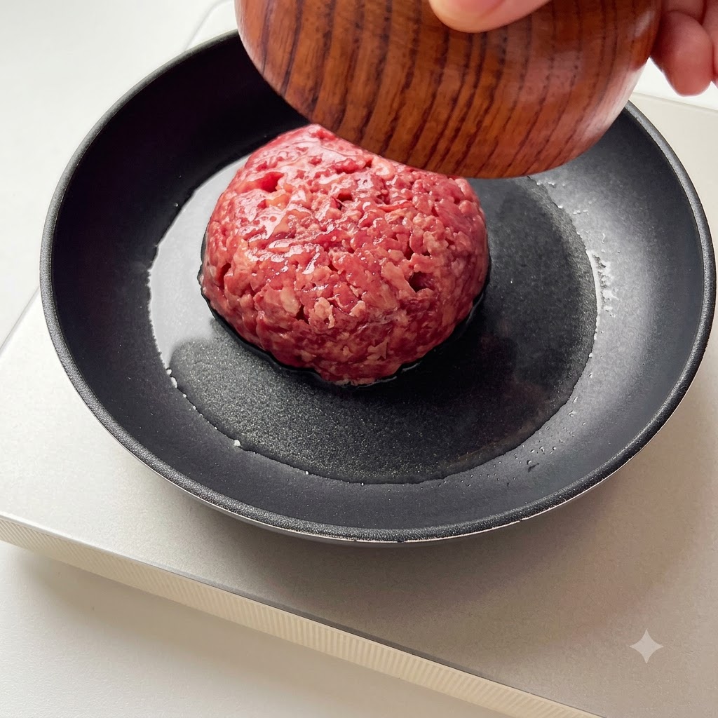 Ground beef being added to a hot frying pan.