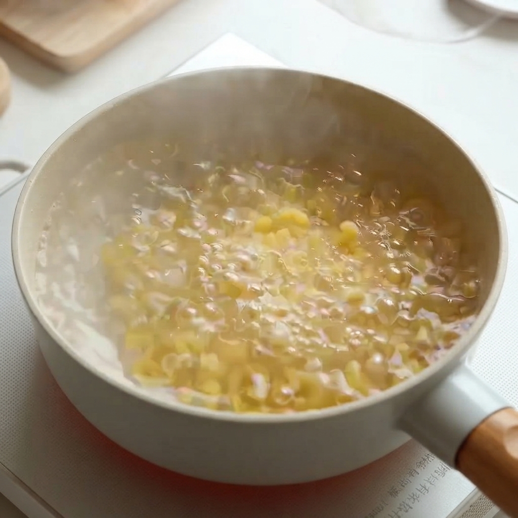 Macaroni pasta boiling in a pot of hot water on the stove.