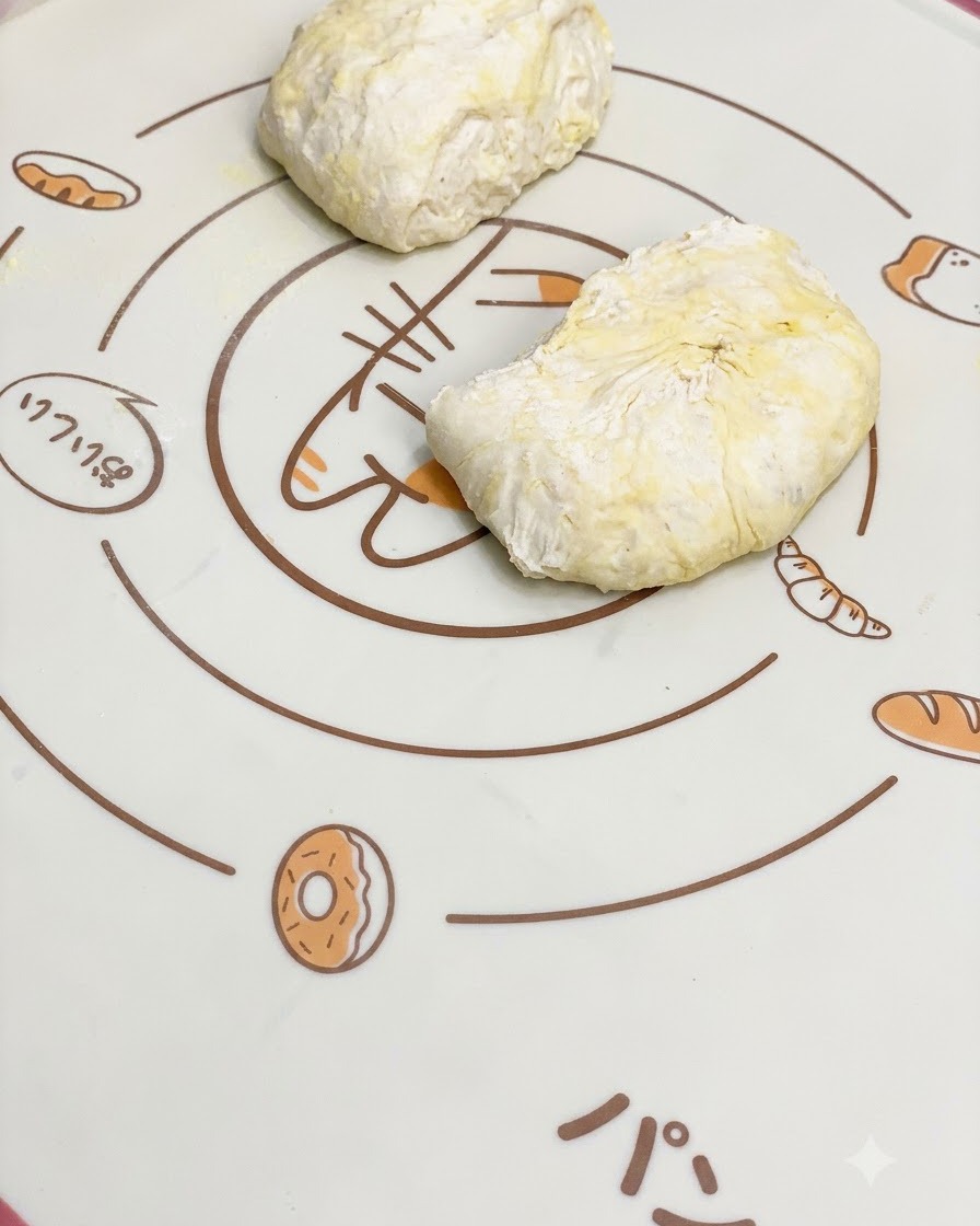 Pieces of fermented pizza dough resting on a patterned silicone baking mat.