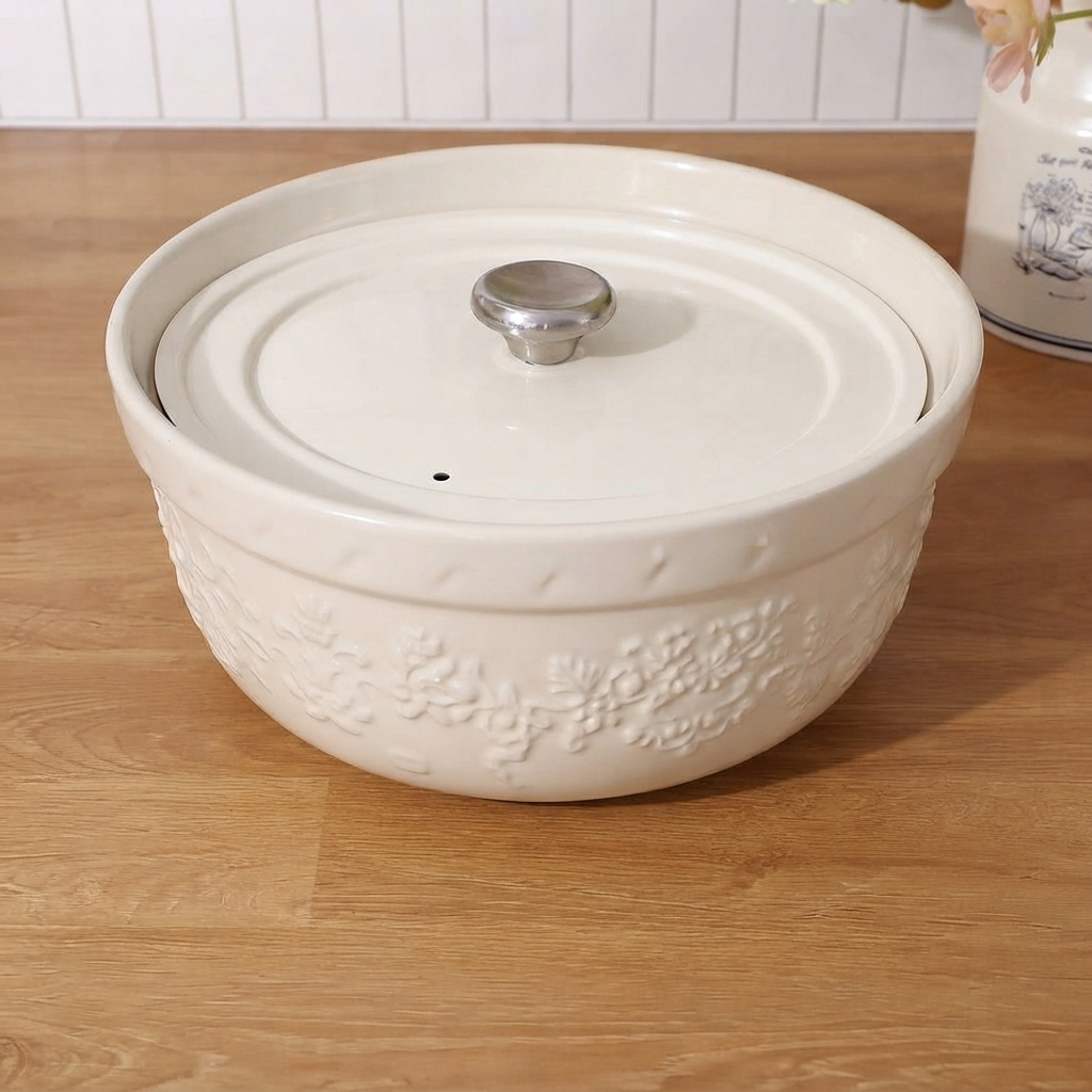 A round ball of pizza dough being kneaded on a wooden countertop by hand.