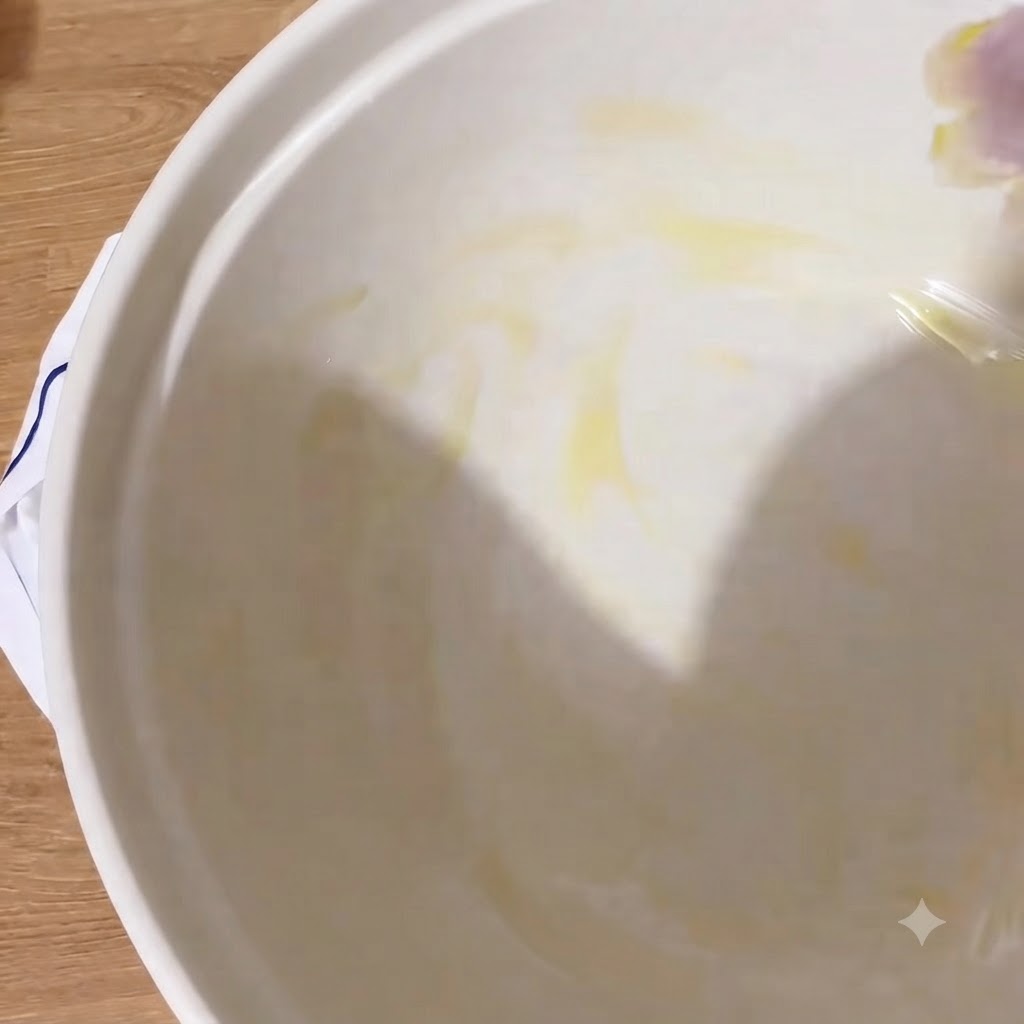 The interior of a white bowl glistening with a layer of extra virgin olive oil.