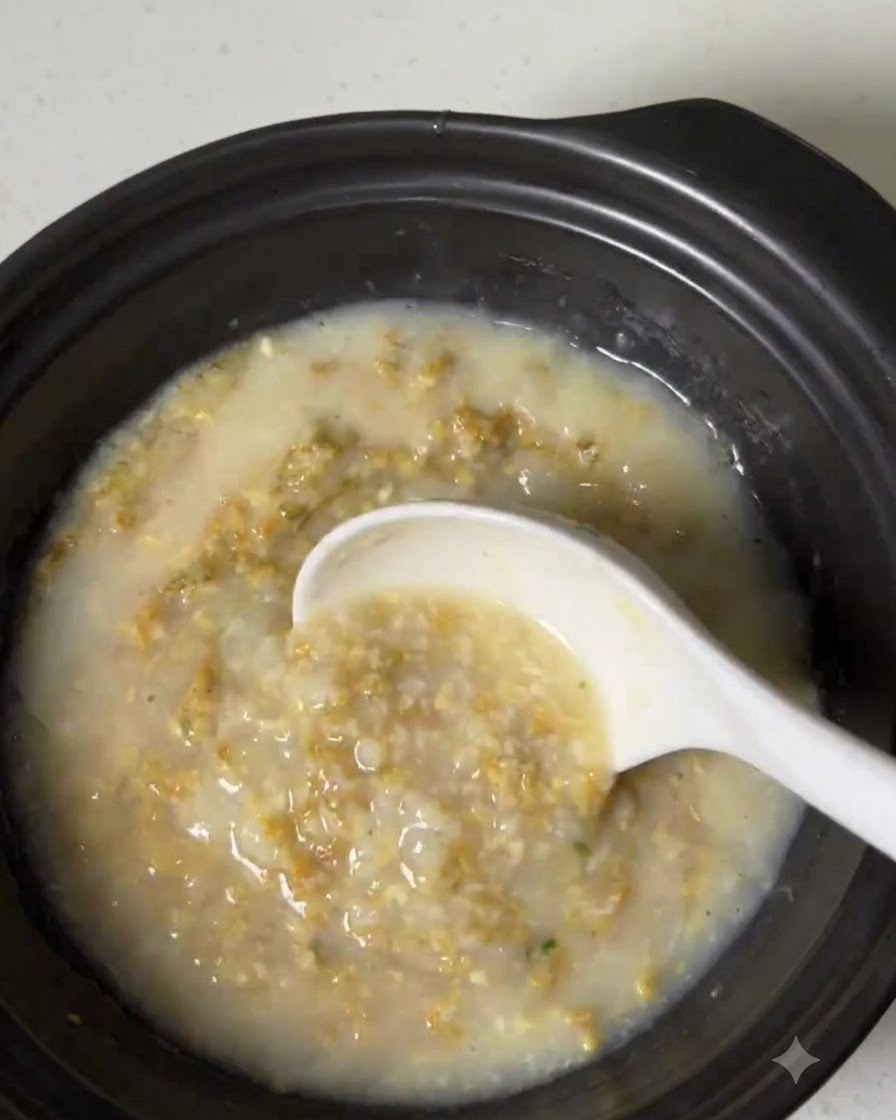 A rich, creamy broth mixture being stirred inside the cooking pot.