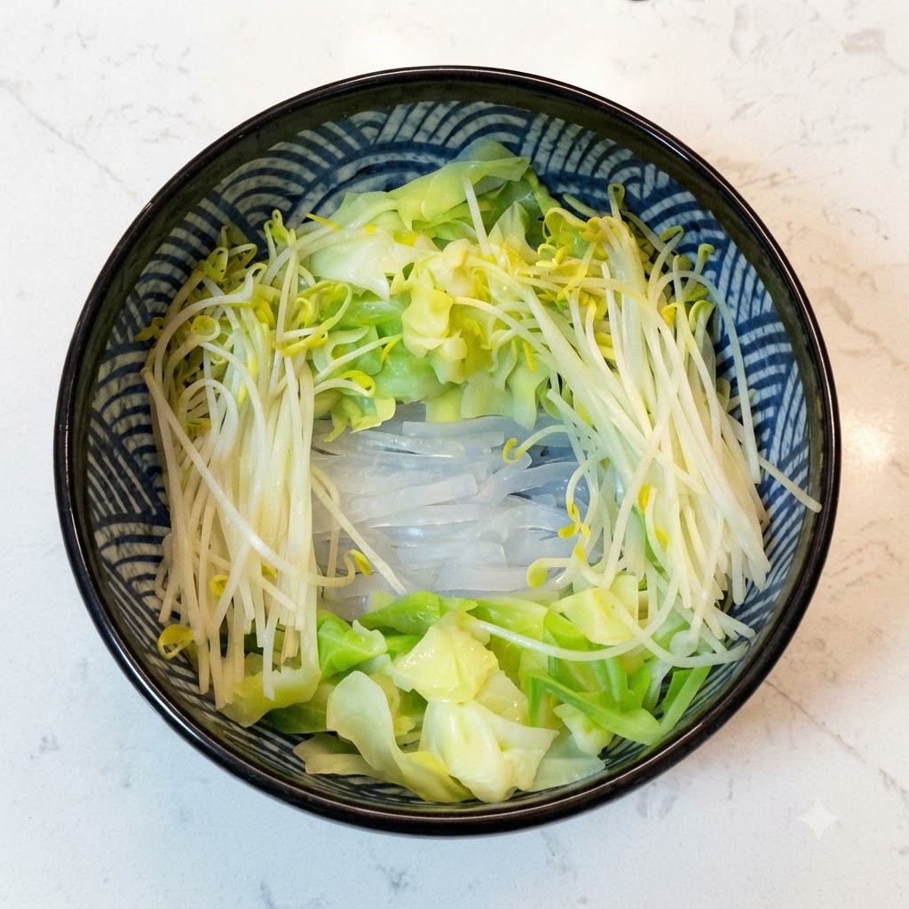 Cooked buckwheat noodles placed inside a bowl surrounded by blanched vegetables.