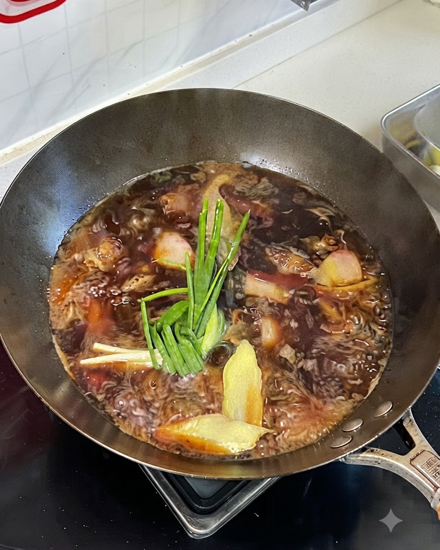 Simmering braising liquid in a wok with green onions, ginger, and spices on top of the beef.