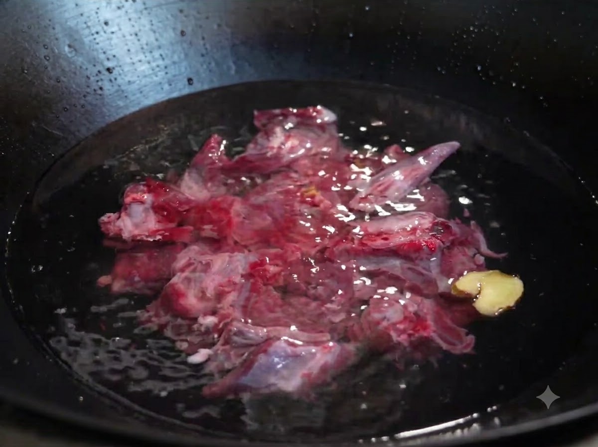 Raw beef ribs submerged in cold water in a wok with sliced ginger and a green onion.