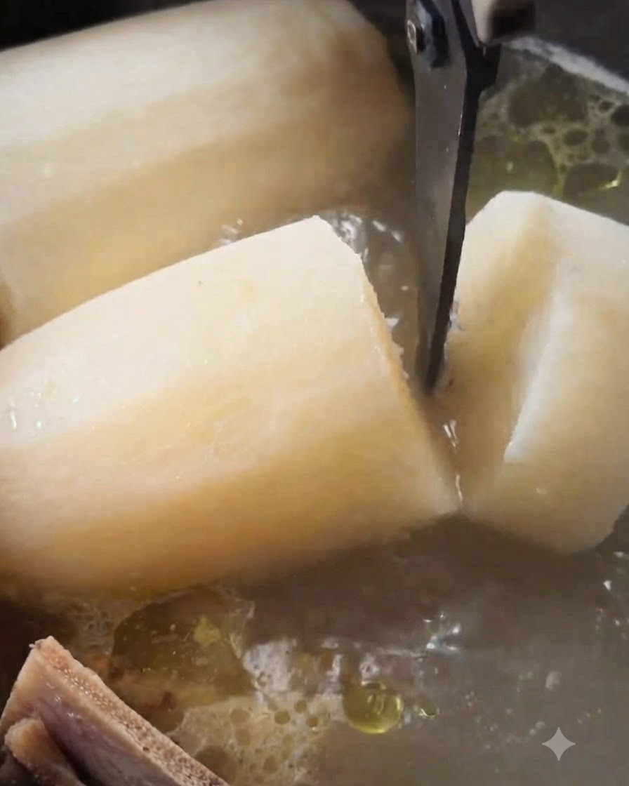 Kitchen scissors cutting through a large, softened piece of white radish inside a simmering pot of beef soup.