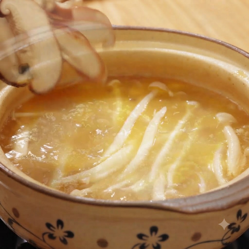 Fresh white beech mushrooms boiling in broth while sliced shiitake mushrooms are being added.