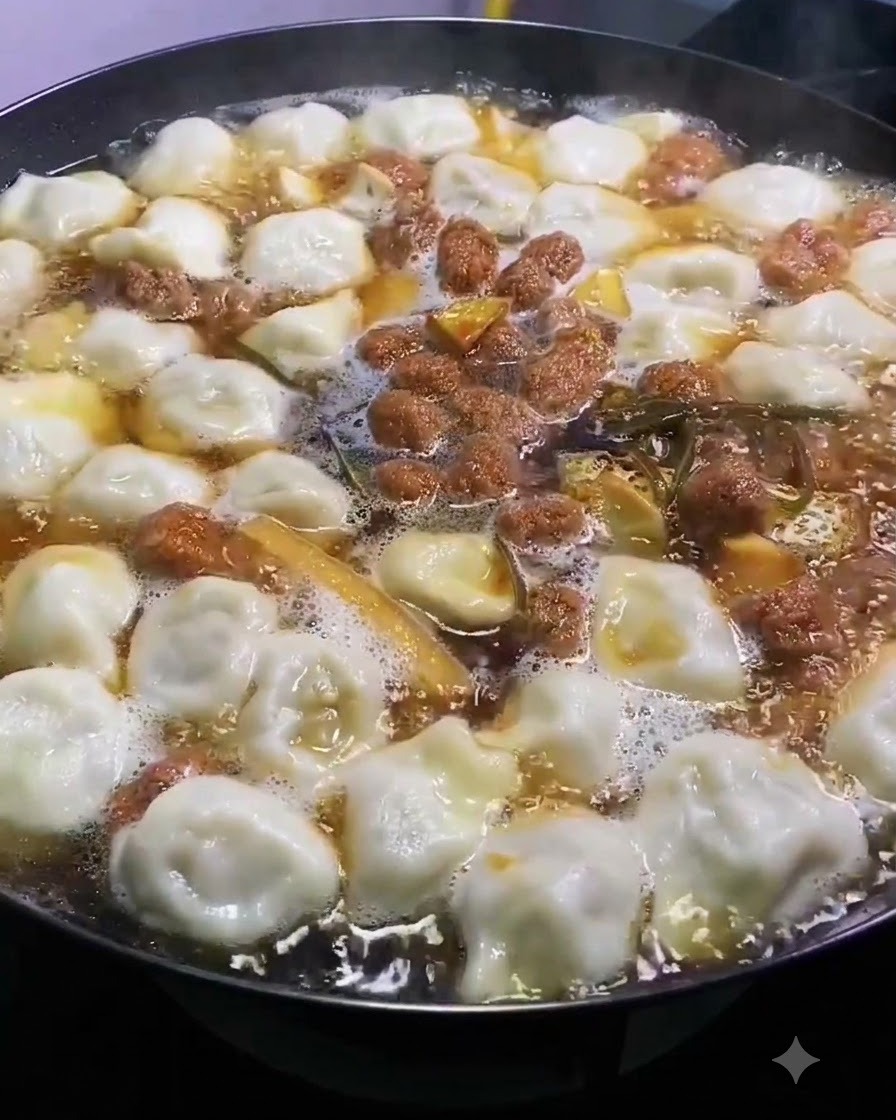 Salt being sprinkled evenly over the top of a bubbling pot of soup and dumplings.