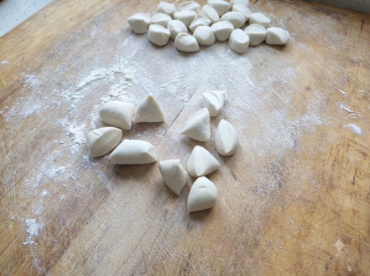 Small pieces of white dumpling dough cut and scattered on a floured wooden board.