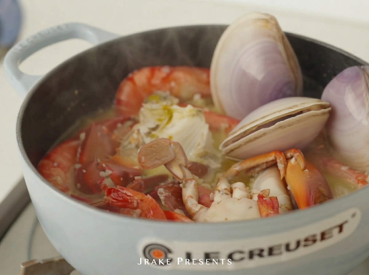 Raw clams and abalone placed in the pot with shrimp and crab.