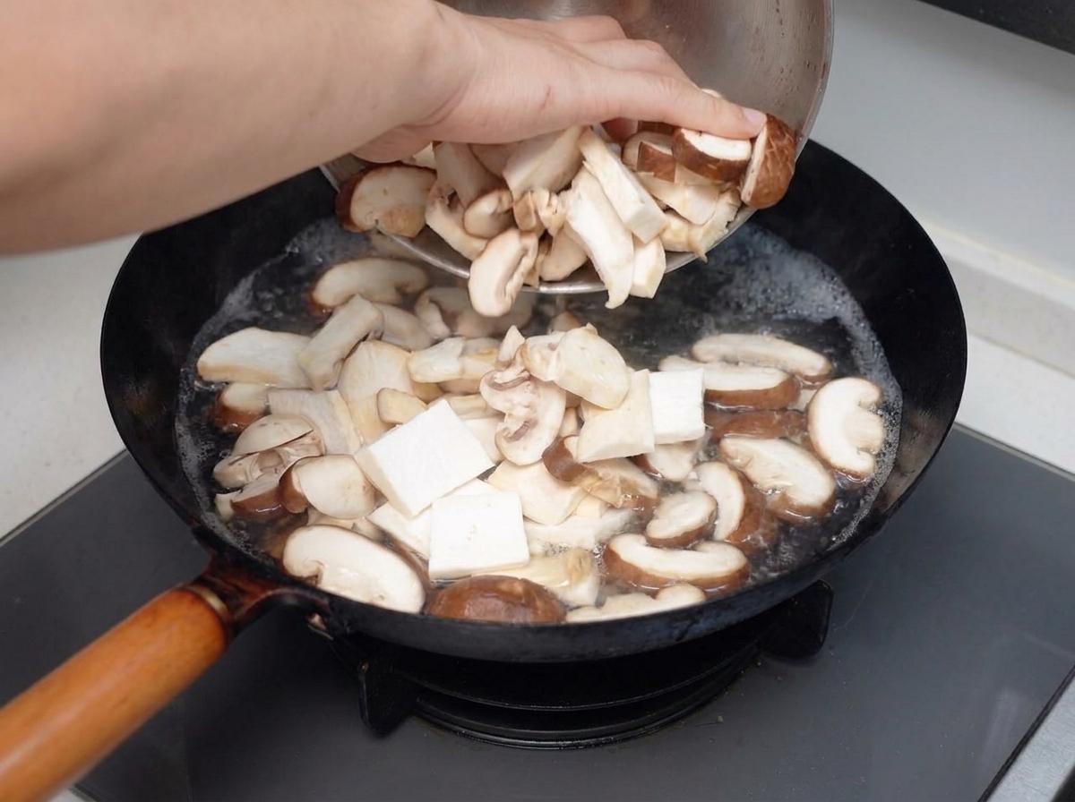 Sliced mixed mushrooms being poured into a boiling pot of water.