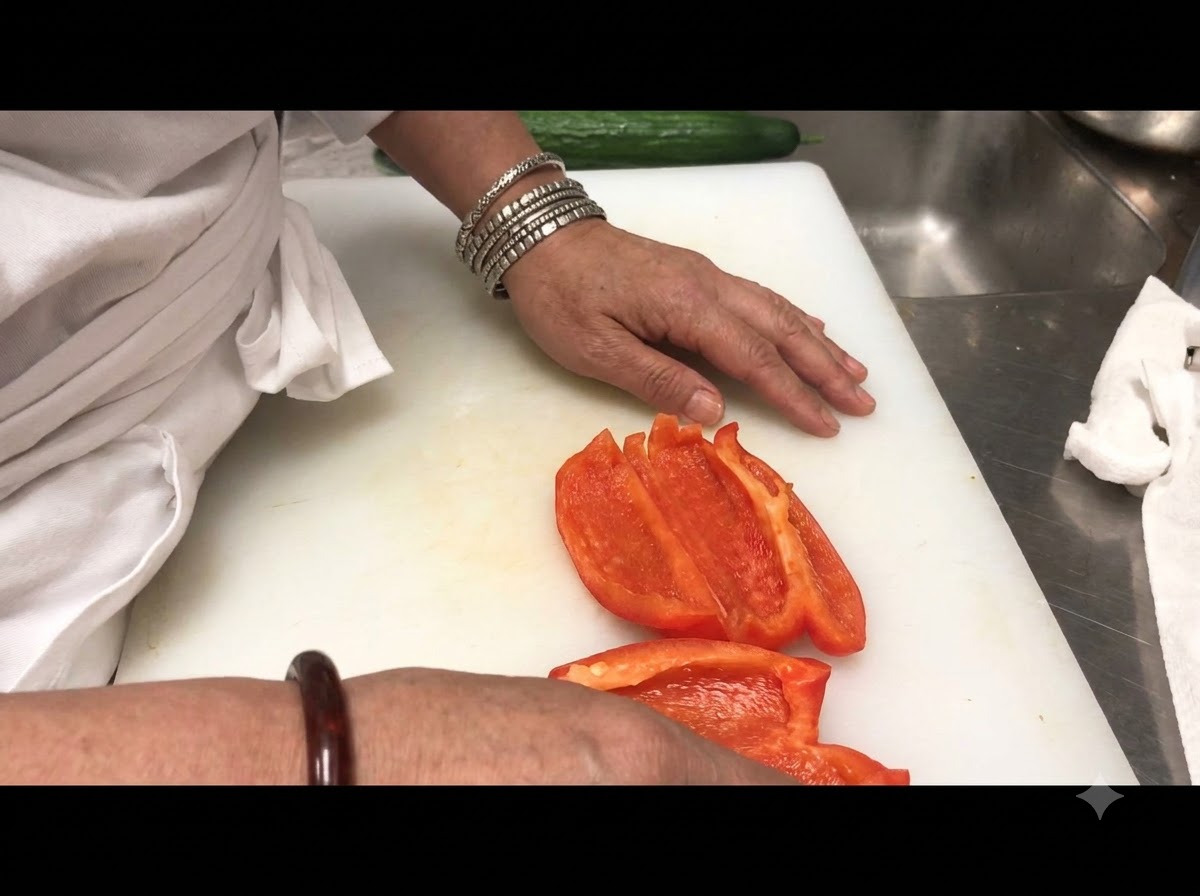 Sliced red bell pepper strips arranged on a white cutting board.