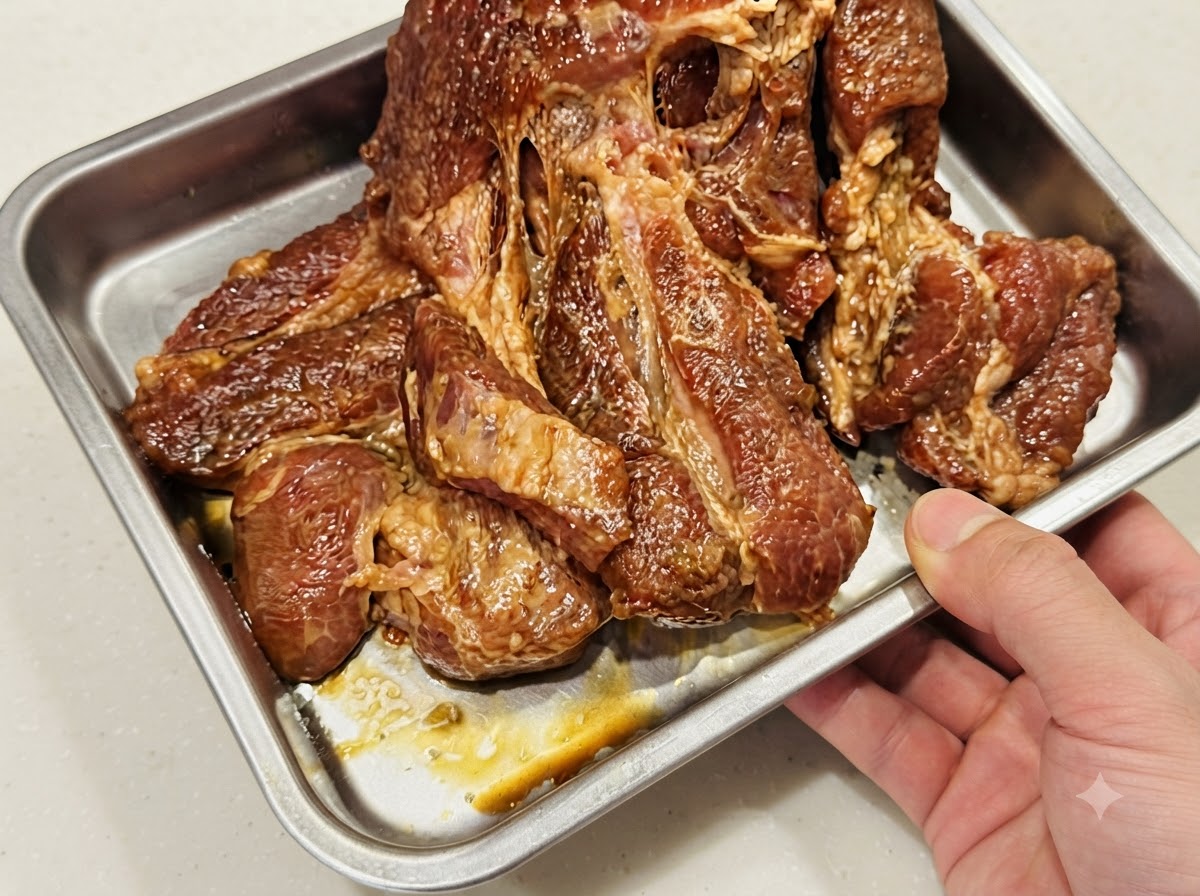 Pork chops laid flat in a single layer inside a foil-lined metal baking tray.