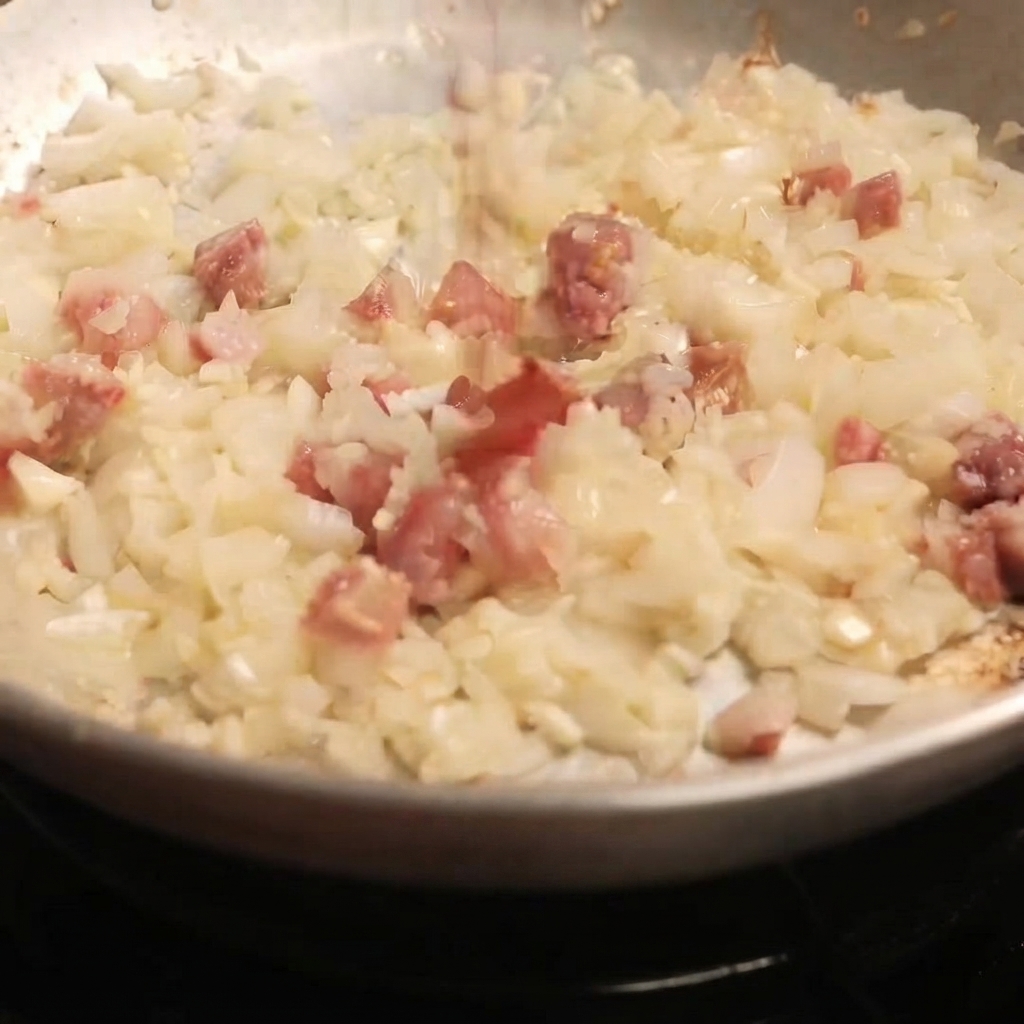 Smoked sweet paprika powder being dusted over the savory mixture in a skillet.