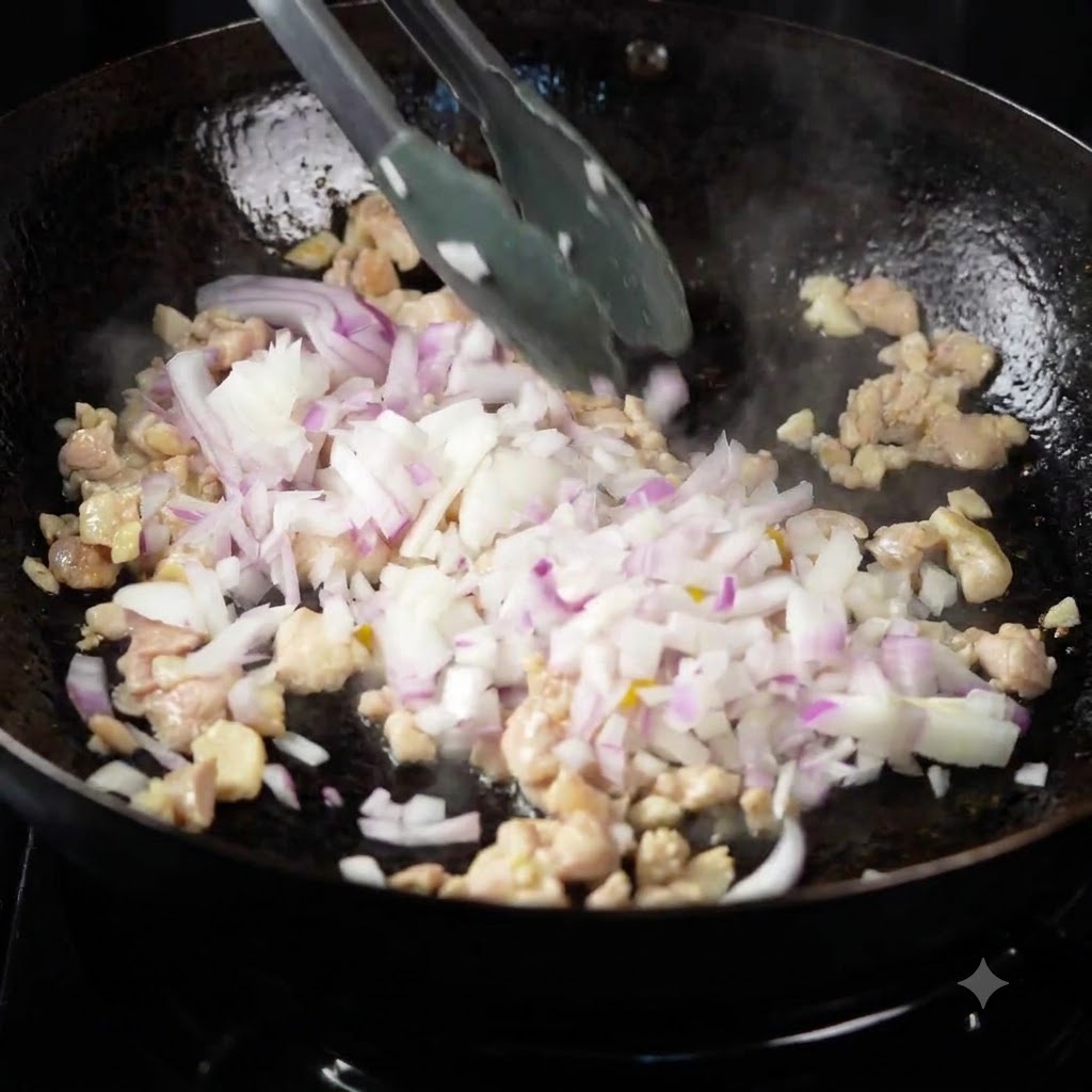 Multi-colored bell peppers, onions, and zucchini being added to the stir-frying chicken in a wok.