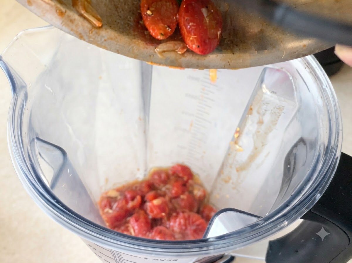 Rich red tomato sauce being poured from a bowl into a pan containing fried garlic and chili.