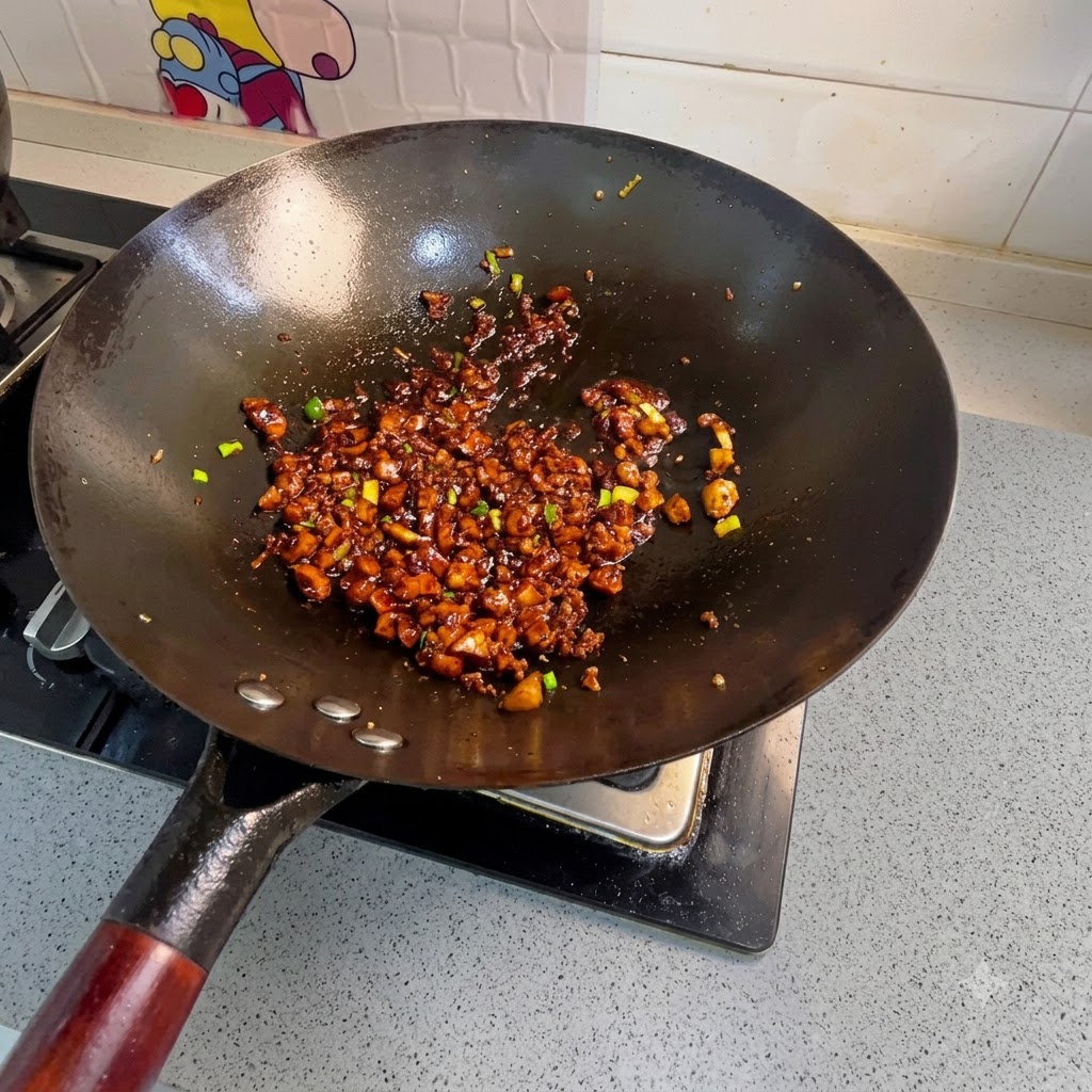 Diced carrots, potatoes, and fried tofu cubes being tossed into the wok with seasoned minced meat.
