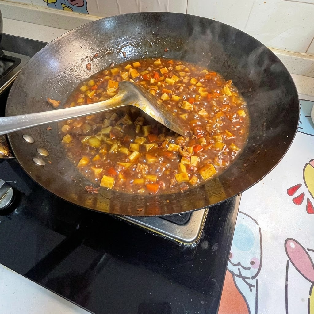 Water starch being stirred into the bubbling sauce in the wok to thicken it.