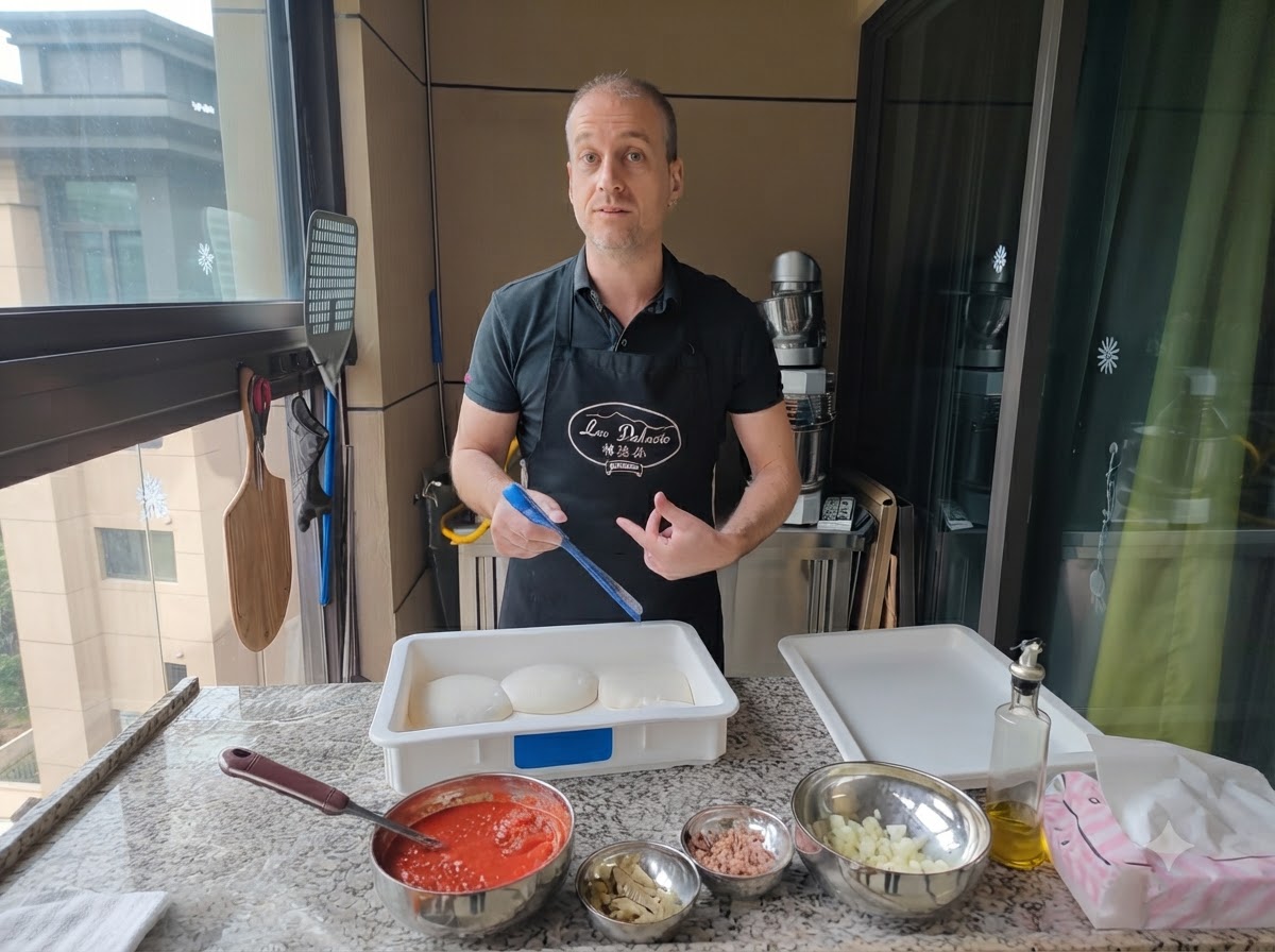 A man using a blue tool to lift a ball of dough from a proofing box.
