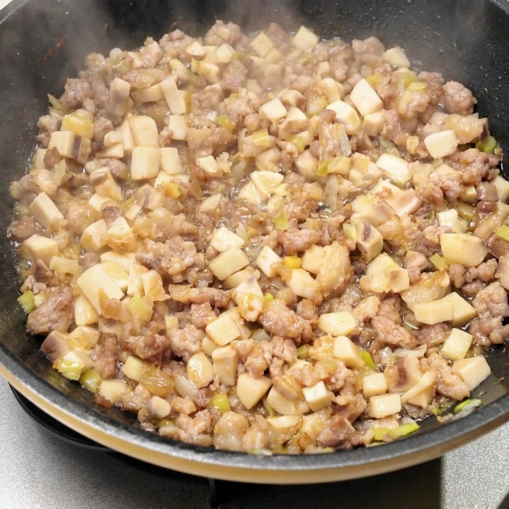 Various liquid seasonings and sauces being poured into the cooking pan with the meat and mushroom mixture.