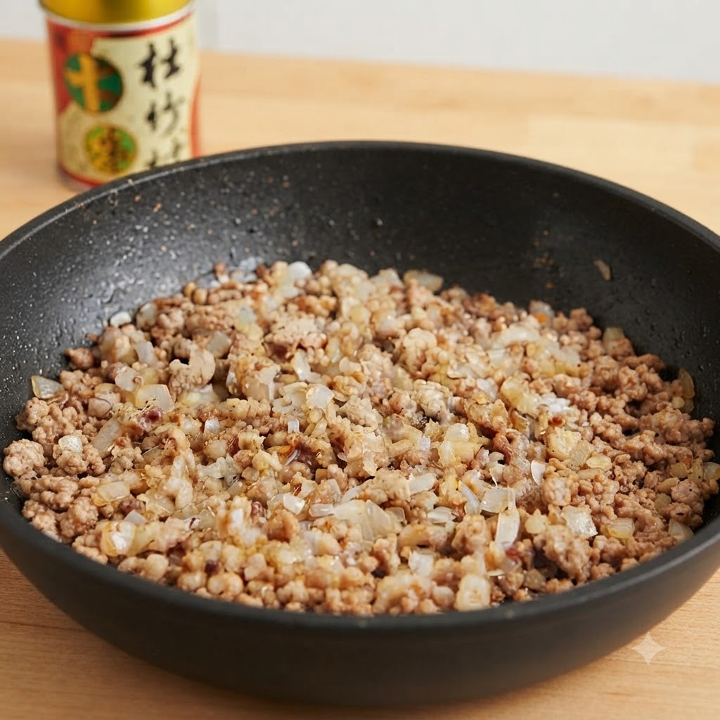 A pan of minced pork and onions being seasoned with various sauces and spices.