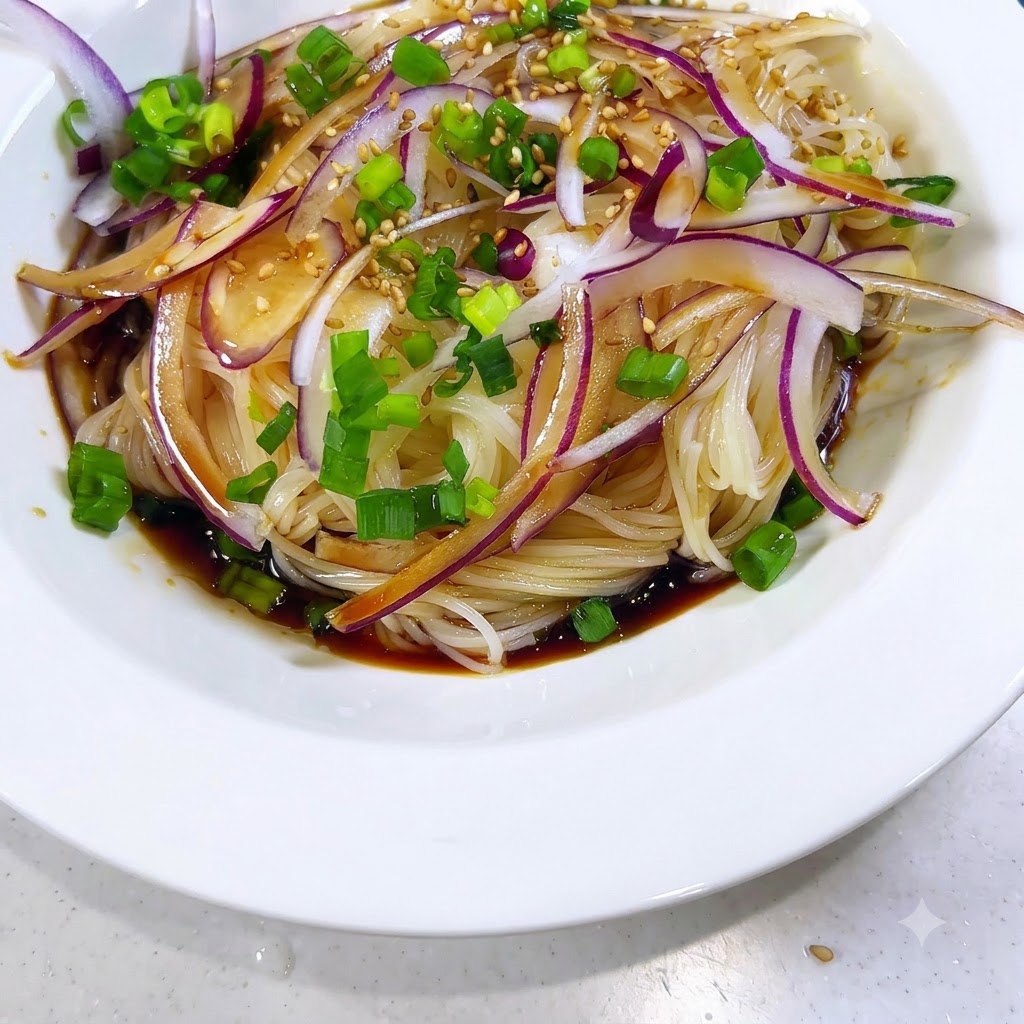 Sesame seeds being scattered over the seasoned noodles, onions, and sauce.