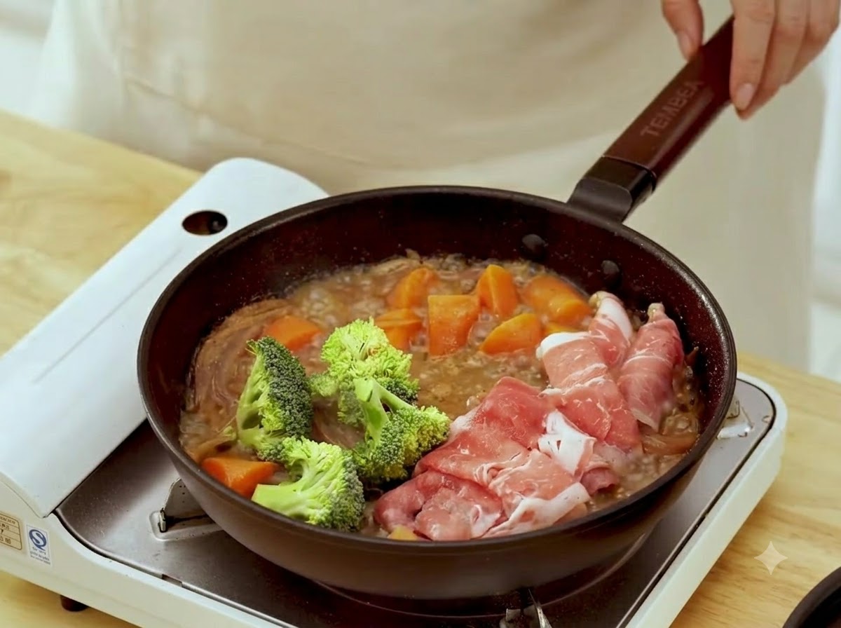 Fresh green broccoli florets added into the simmering pan next to the cooking rolled beef slices.