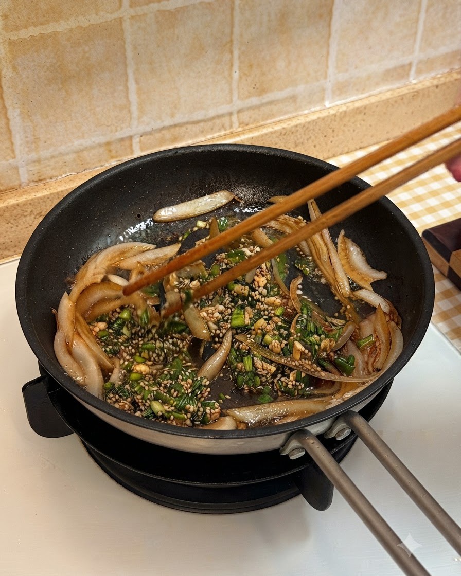 Cooked beef slices being added to the pan and tossed with onions and sauce using wooden chopsticks.