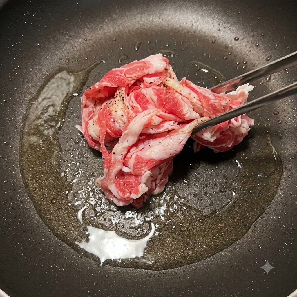 Beef slices being stir-fried in a pan until browned.