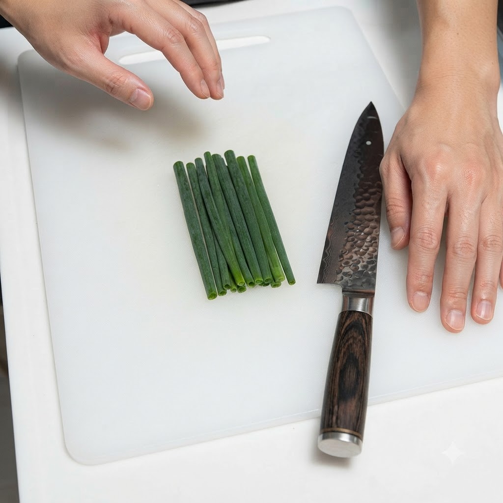 A bundle of green onions neatly arranged next to a kitchen knife on a white cutting board.