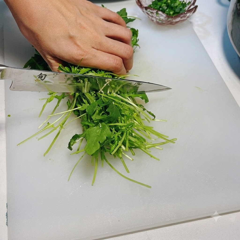 Fresh green arugula being cut with a knife on a white cutting board.
