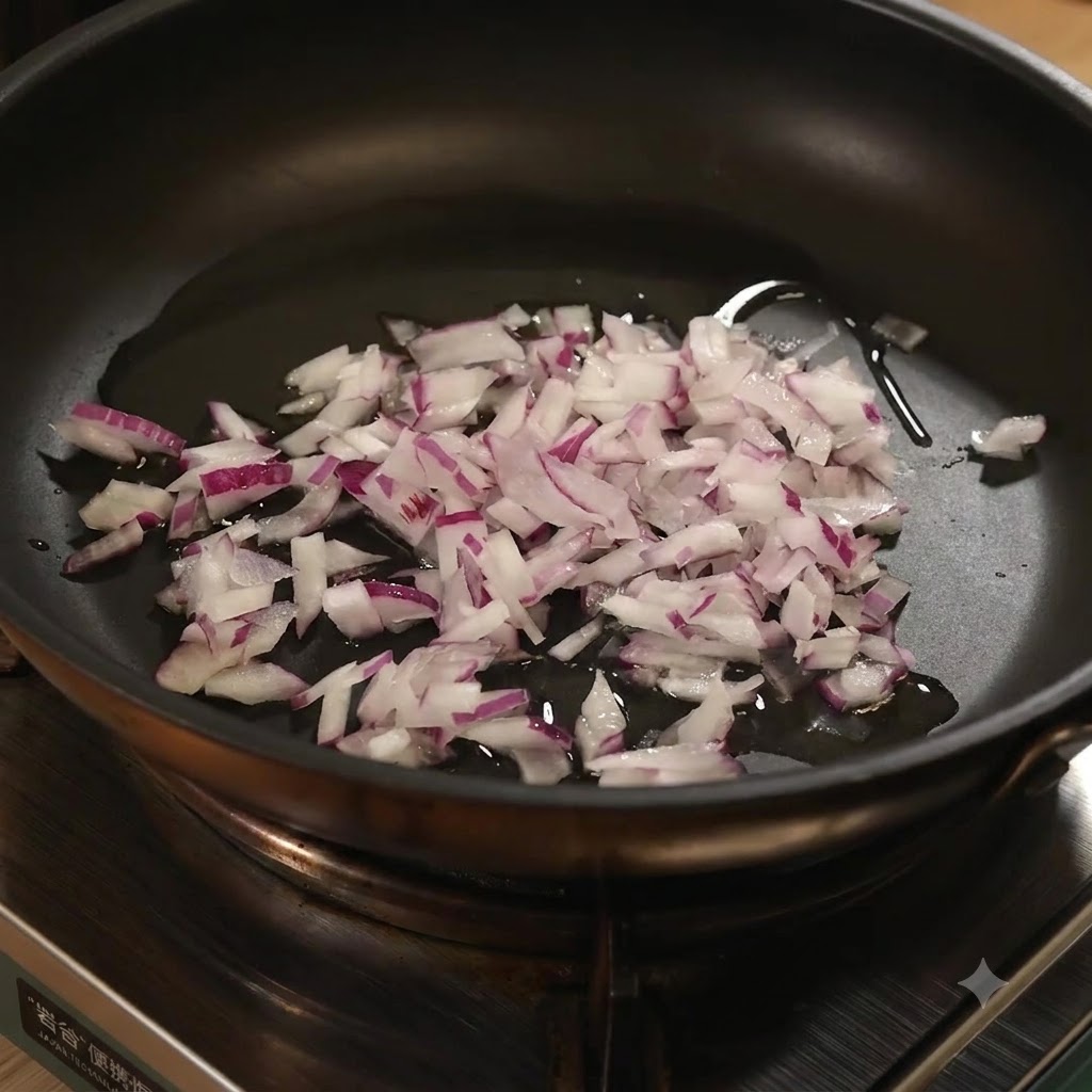 Minced garlic added into the frying pan with chopped red onions and oil.