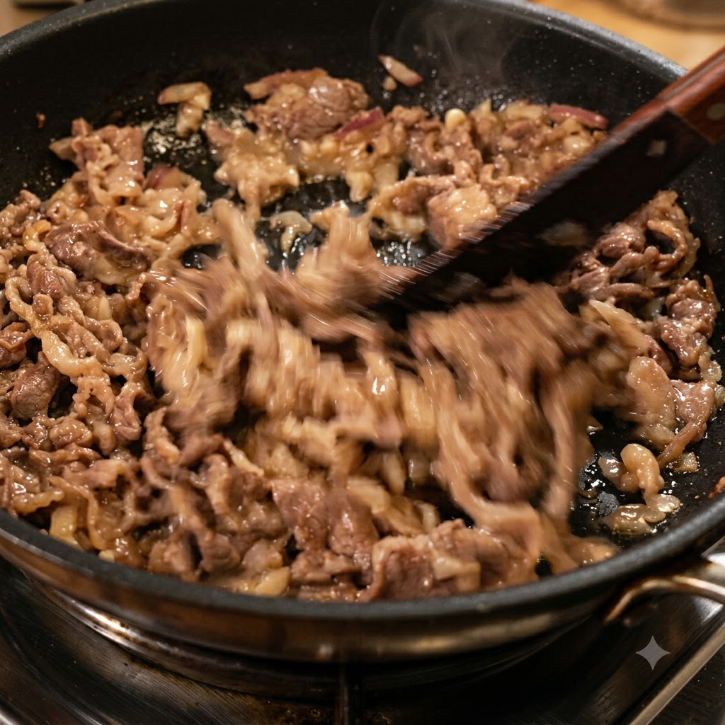 Chopped dried red chili peppers being stir-fried with beef and onions in a frying pan.