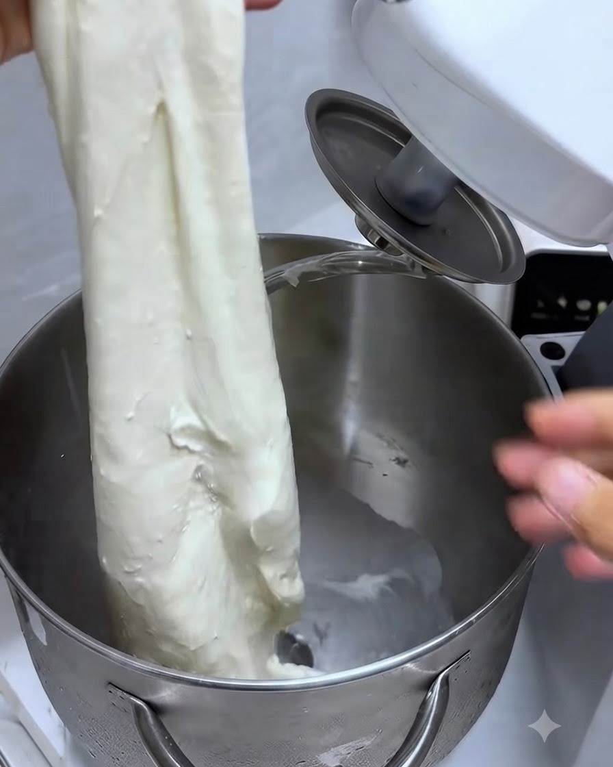 Stretching a piece of dough to show a strong, elastic glove-like membrane.