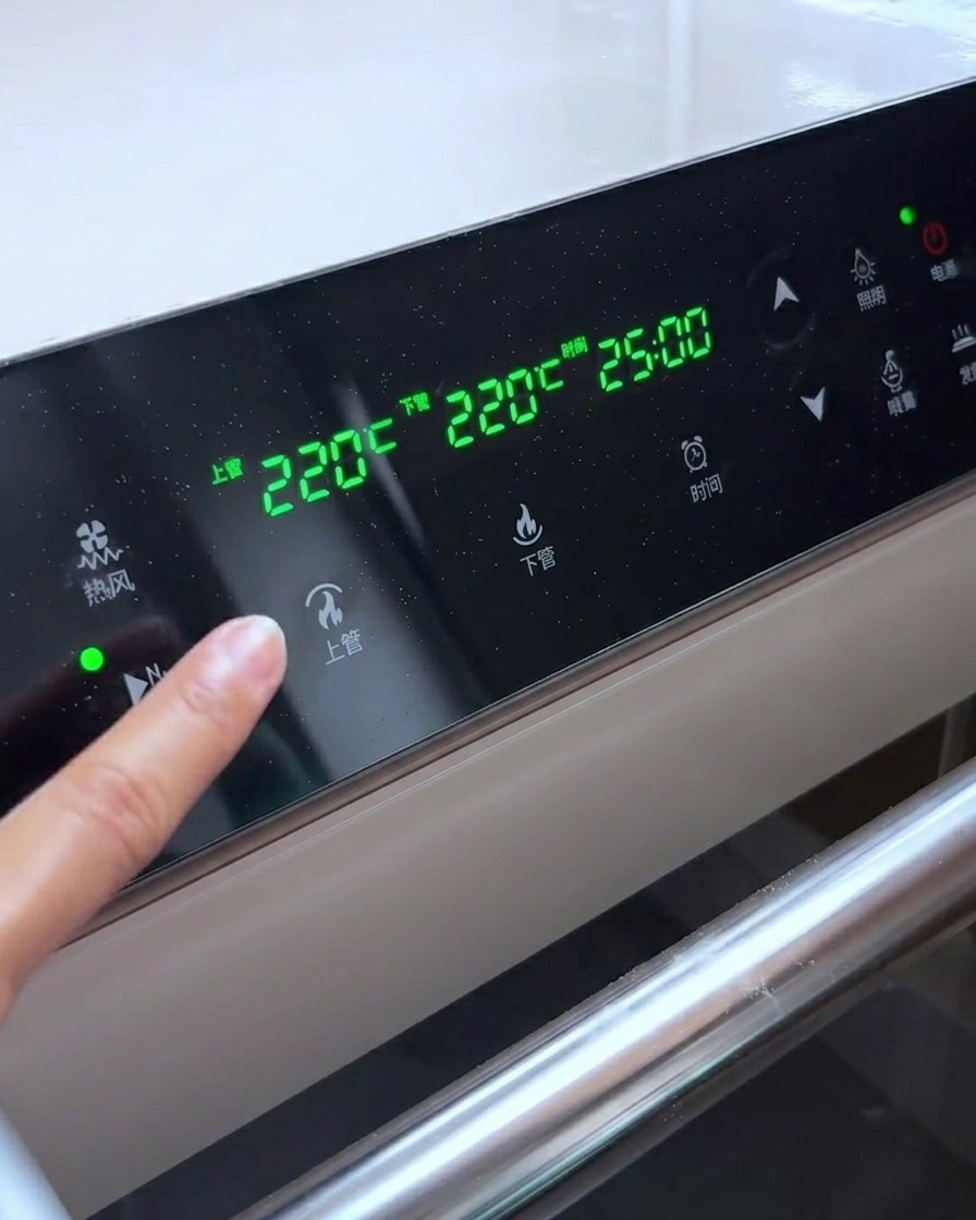 Oven control panel displaying temperature settings of 220°C for both upper and lower heating elements.