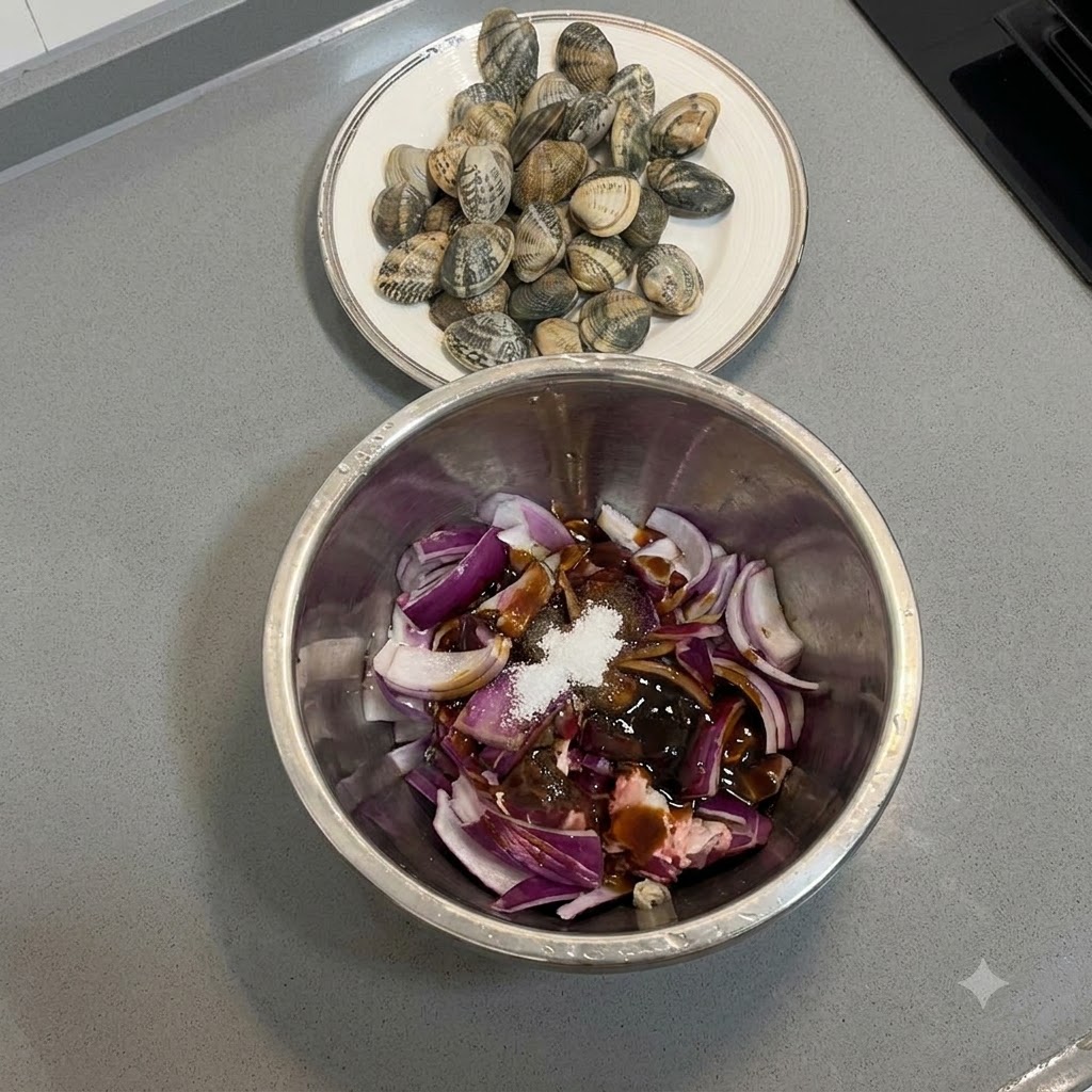 Beef pieces and red onions being mixed with marinades in a metal bowl using a gloved hand.