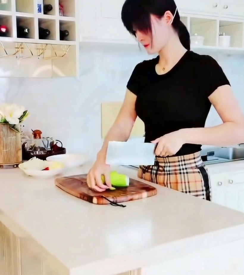 A close-up of green zucchini being sliced into small triangular pieces on a wooden cutting board.