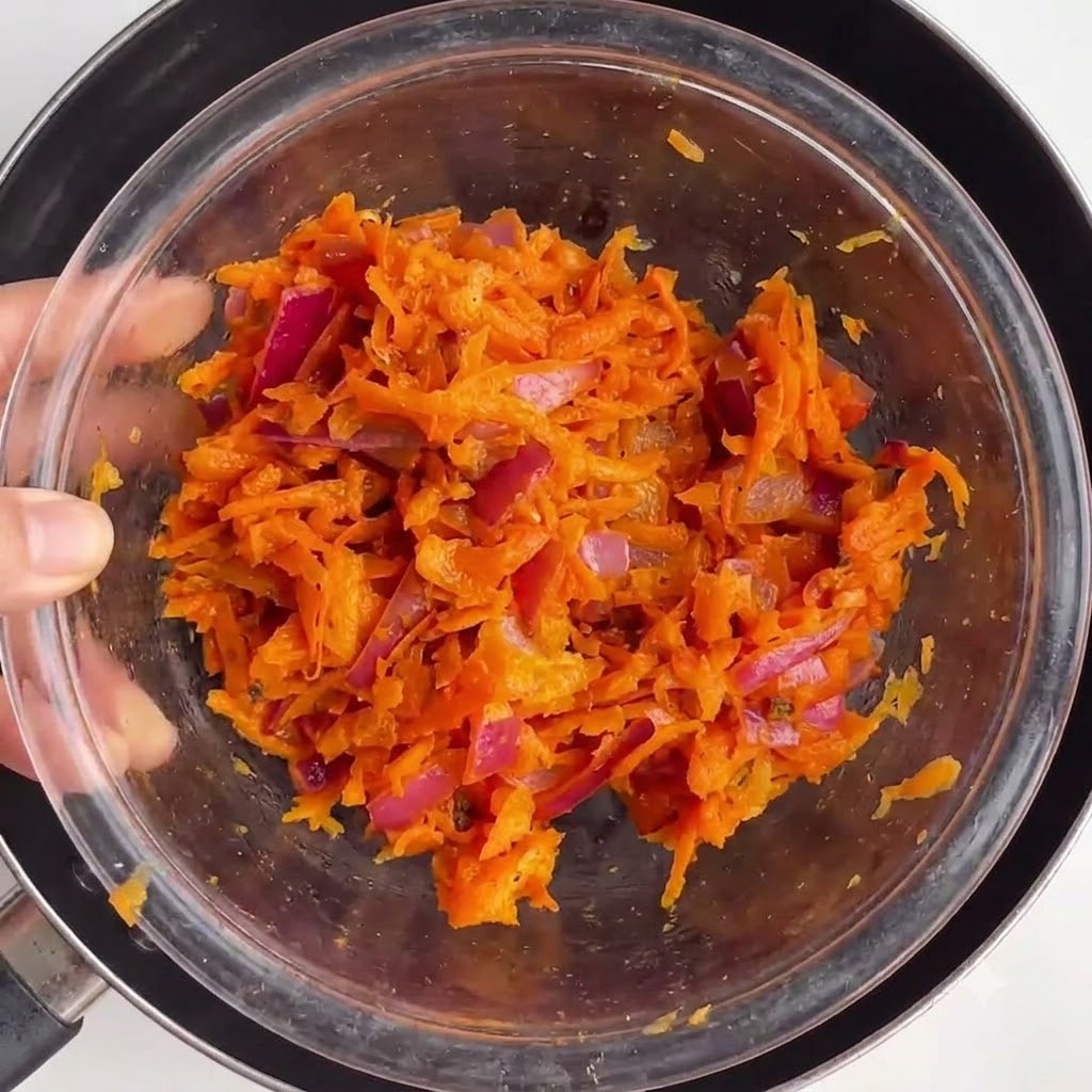 Bowl containing the cooked vegetable mixture set inside a pan.