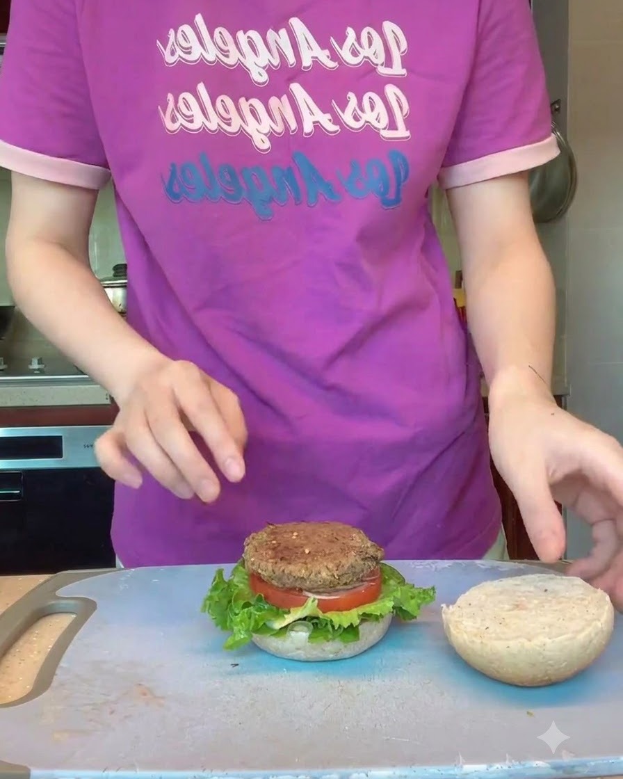 A tray filled with shaped black bean burger patties being loaded into an oven.