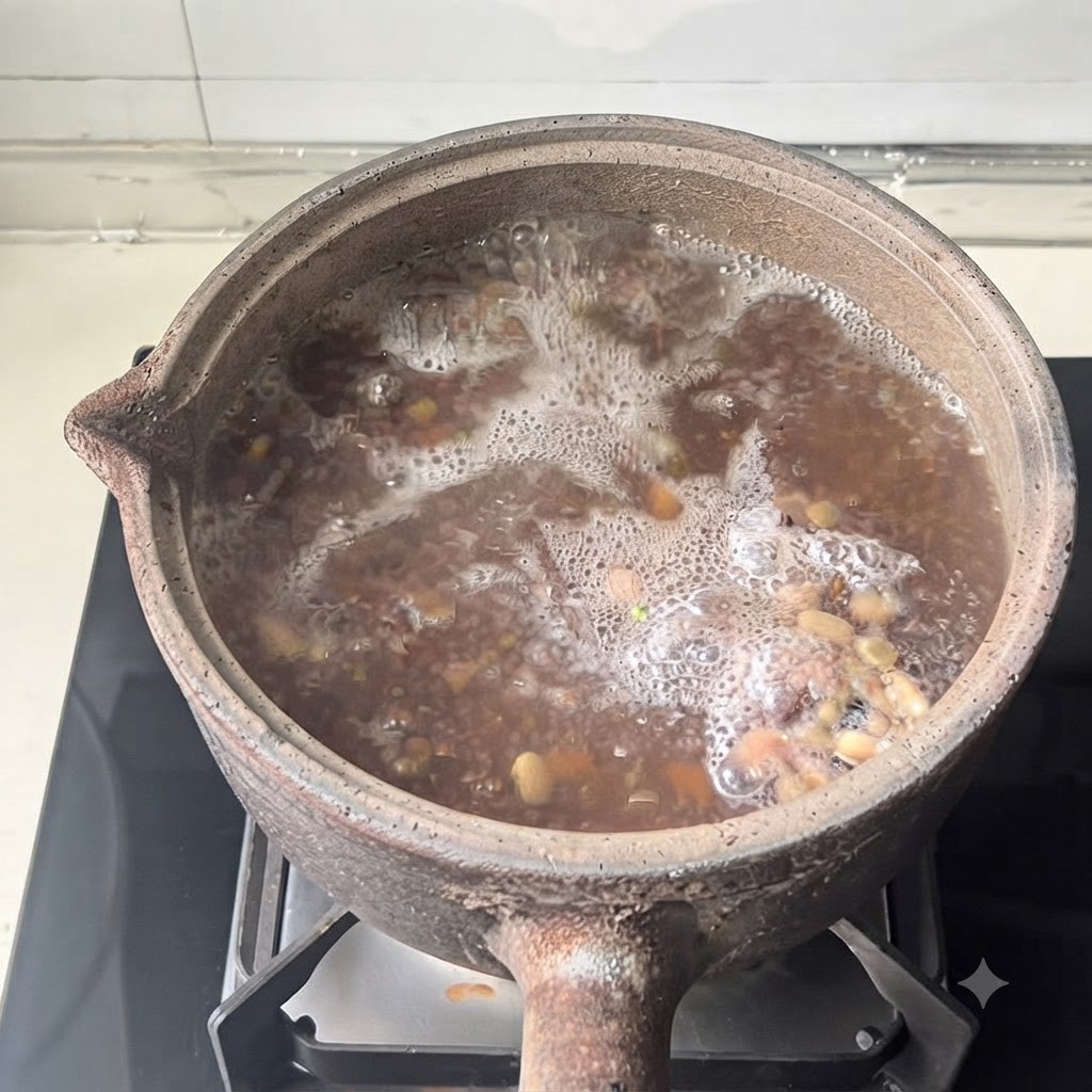 An earthenware pot with its lid on sits atop a modern stove burner during the cooking process.