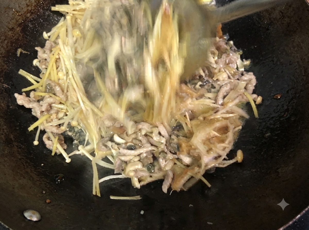 Ingredients being actively stirred and mixed in the wok with a metal spatula.